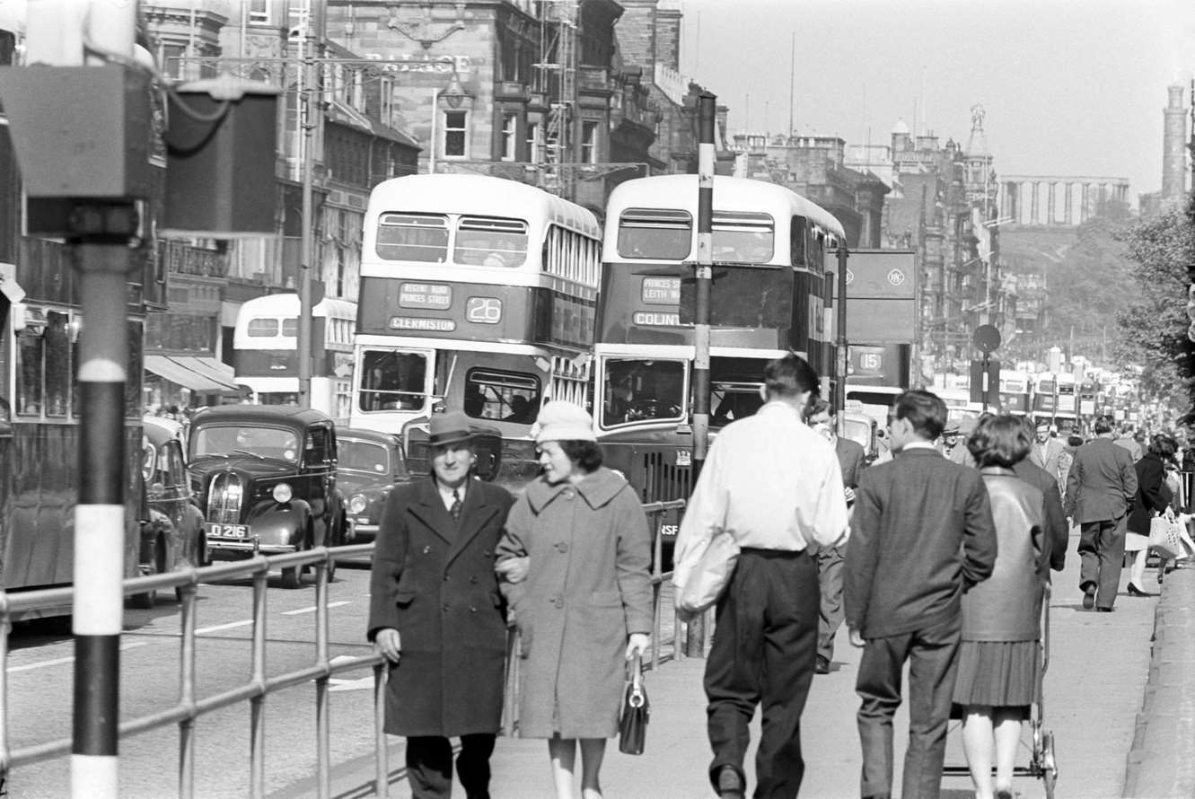 Road traffic in the street; in a close-up, can be seen typical two-level British buses, Scotland, 1964