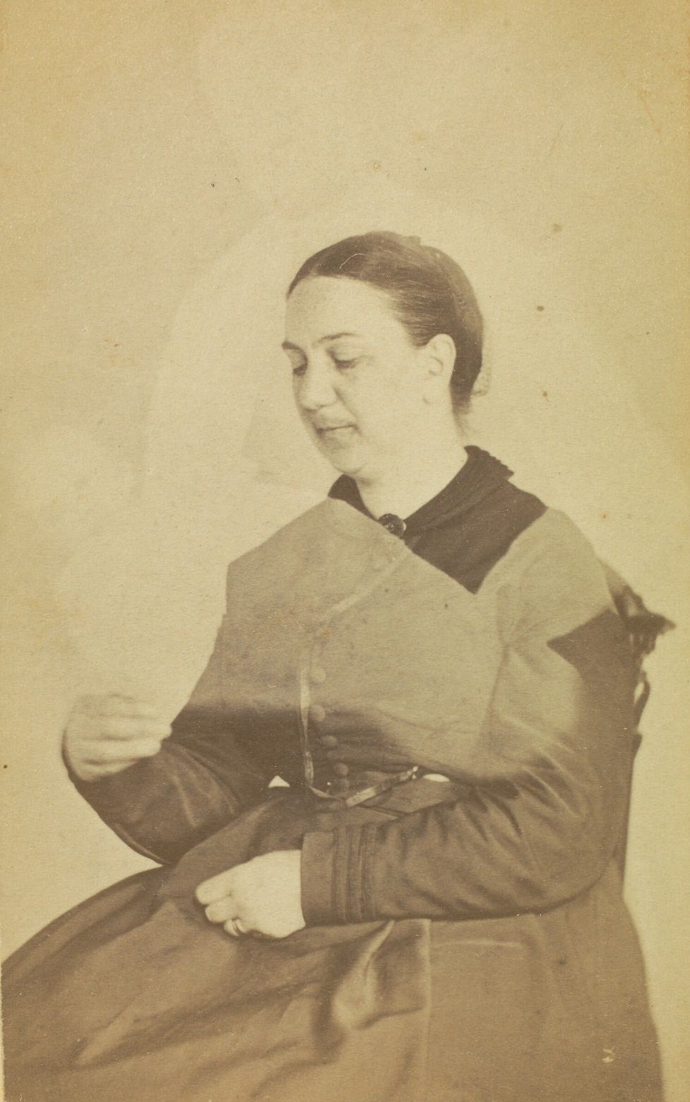 Portrait of Mrs. H.B. Sawyer, looking down at her hand. The faint image of a person is visible above her, with the faint image of a baby across her.