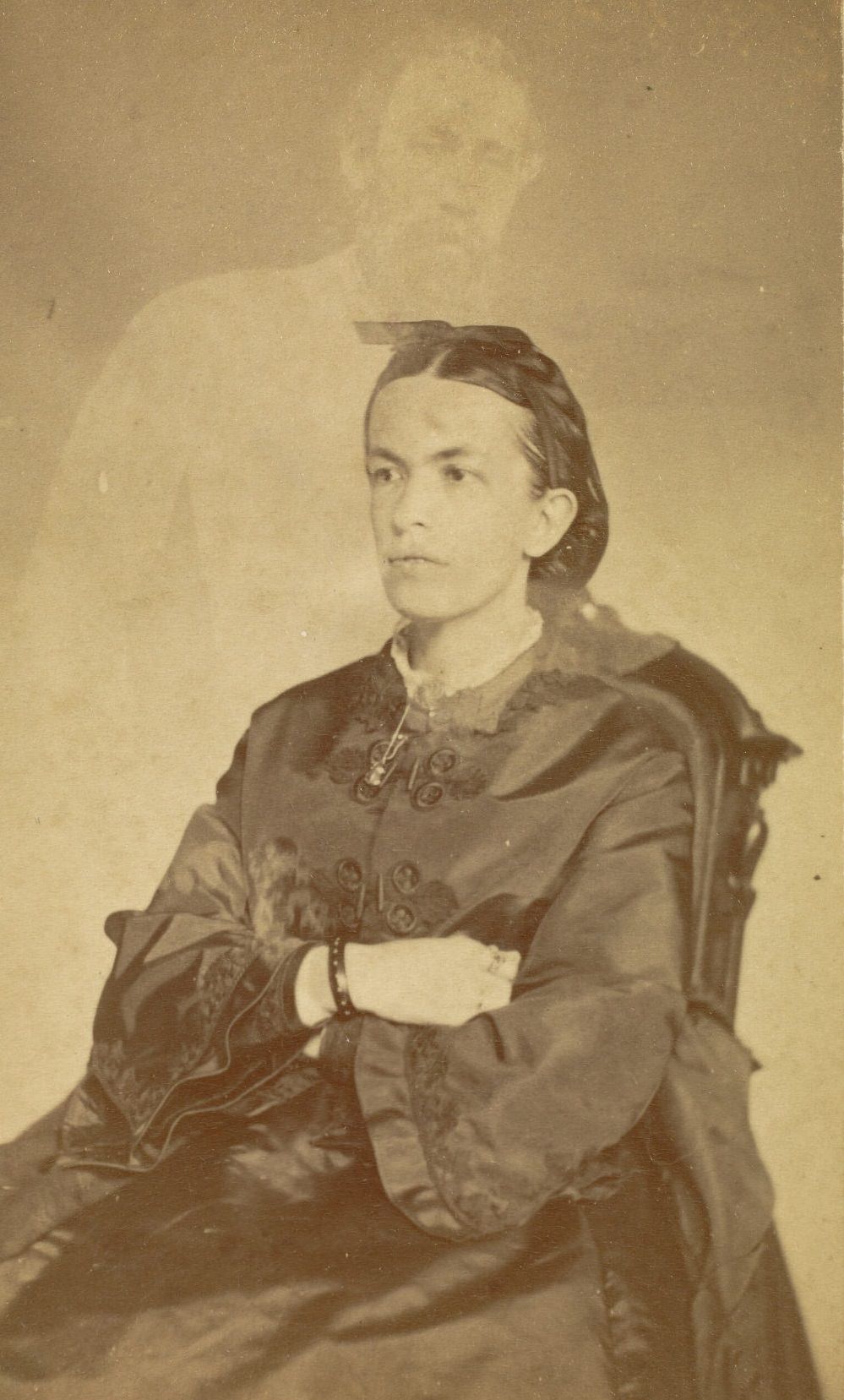 Portrait of Mrs. Conant with her arms crossed. The faint image of a bearded man appears above her.