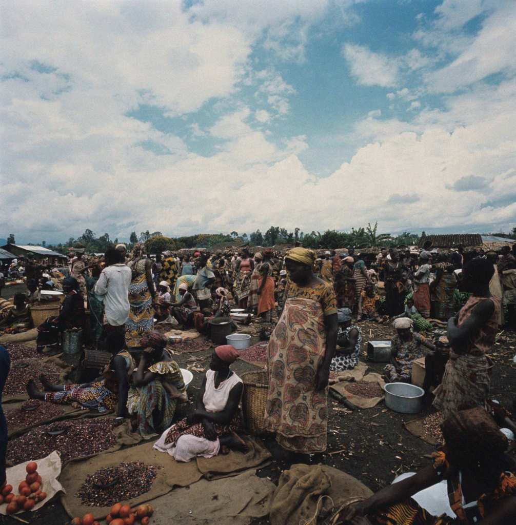 Women waiting to sell their goods on display on mats at the market. Africa, 1960s
