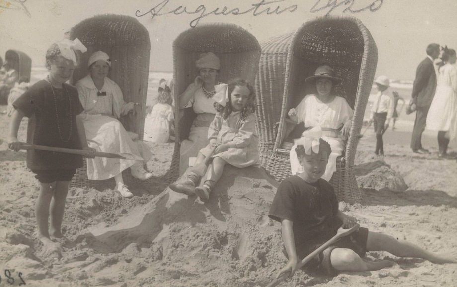 Three women and children in wicker beach chairs on the beach at Wijk aan Zee, 1920