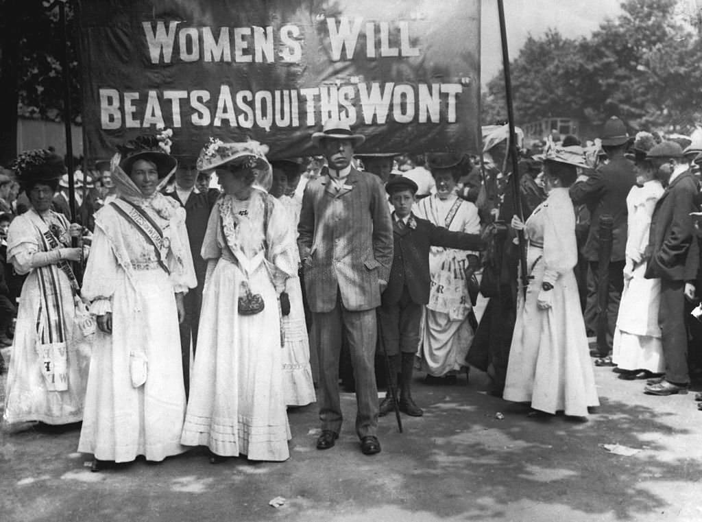 Suffragettes dressed in their white uniforms carry a banner at the funeral of their fellow campaigner Emily Davison, who died making a protest at the 1913 Epsom Derby.