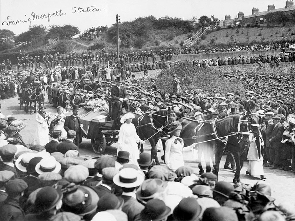 A large crowd watches Emily Wilding Davison's funeral procession leaving Morpeth station, 15th June 1913.