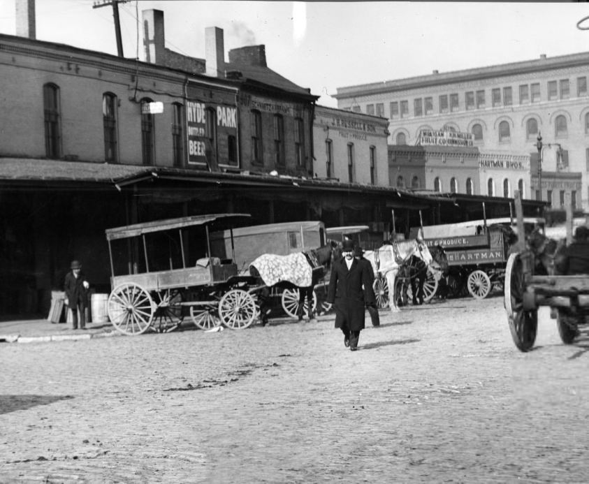 Row of produce vendors along North Fourth Street, 1908. A horse-drawn carts are visible in front of the businesses.