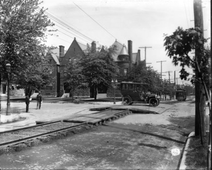 Automobile crossing streetcar tracks over wooden road crossing, 1909