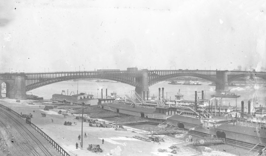 The riverbank and bridge; the Saint Louis and Tennessee River Packet Company, the Consolidated Coal Company, Cape Girardeau and Commerce, and Diamond Line Steamers line the river side, 1904