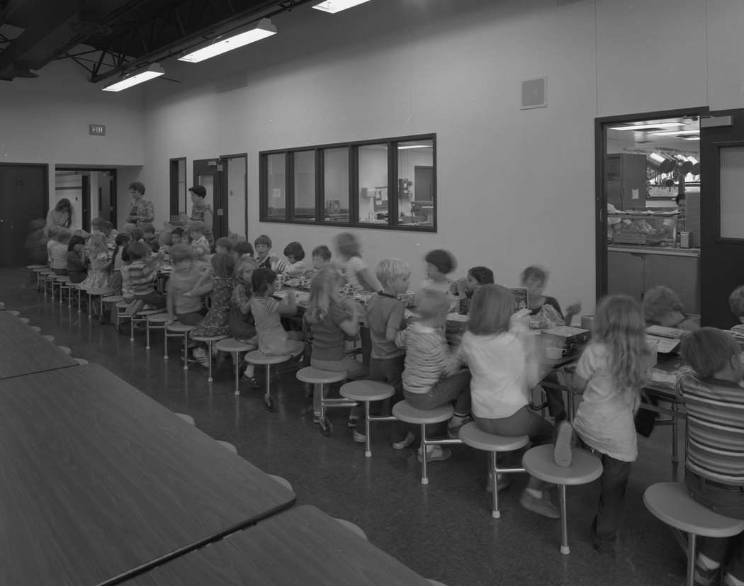 A group of school children eating lunch in the Pflugerville Elementary School cafeteria, 1978