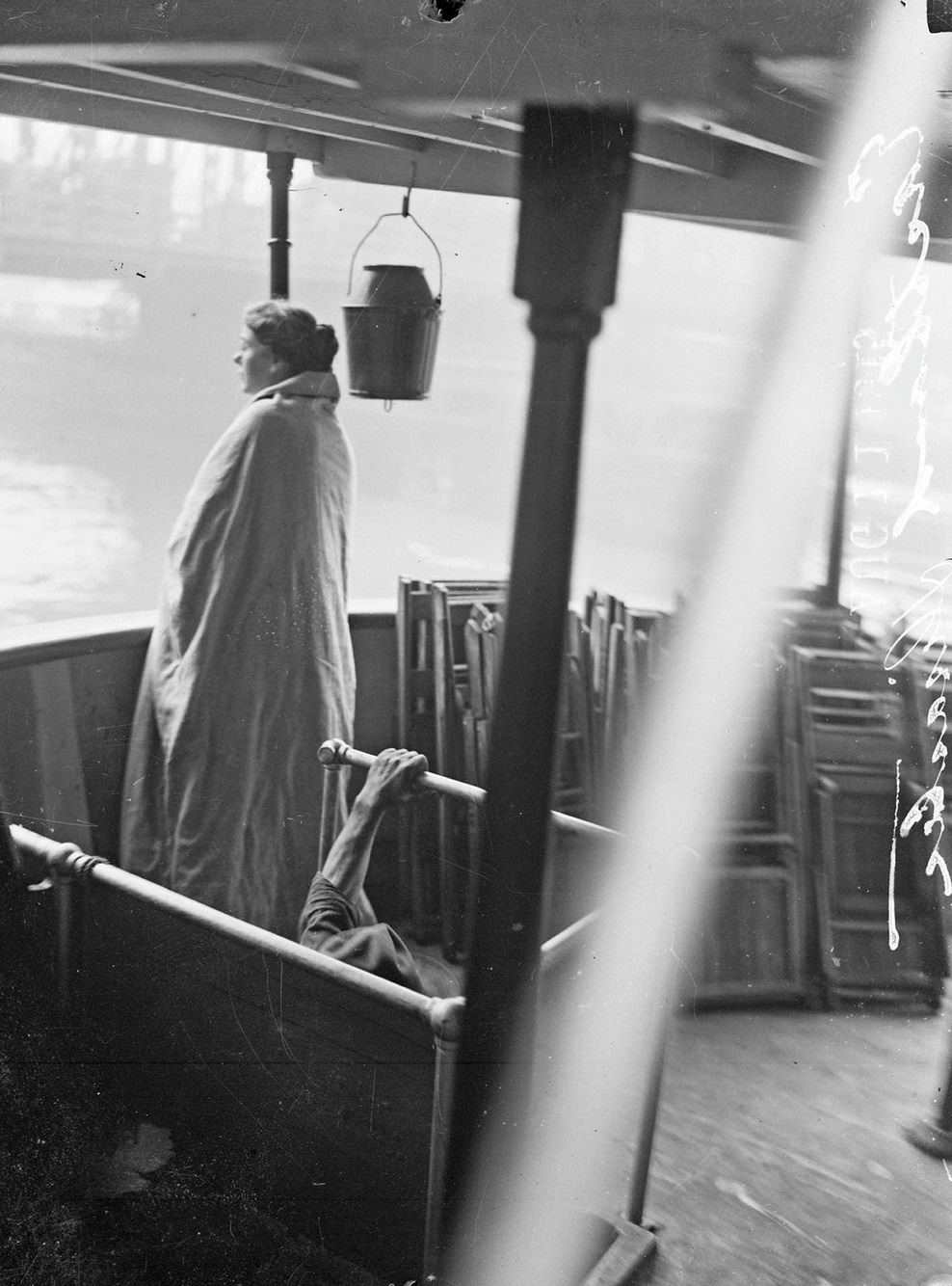 Eastland disaster, female survivor, wrapped in a blanket, standing on upper deck of a boat, Chicago, Illinois, July 24, 1915.