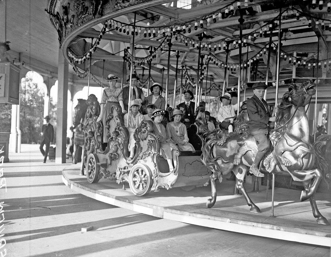 Children and adults on merry-go-round at Riverview Park, Chicago, Illinois, 1915.