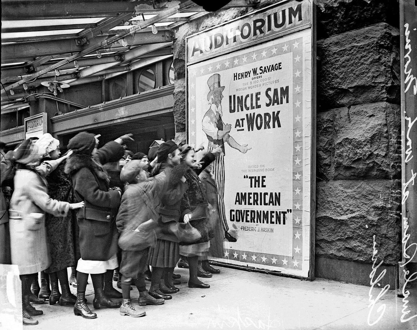 Children pointing at a movie poster for Uncle Sam at Work at the Auditorium Theater, Chicago, Illinois, February 20, 1915.
