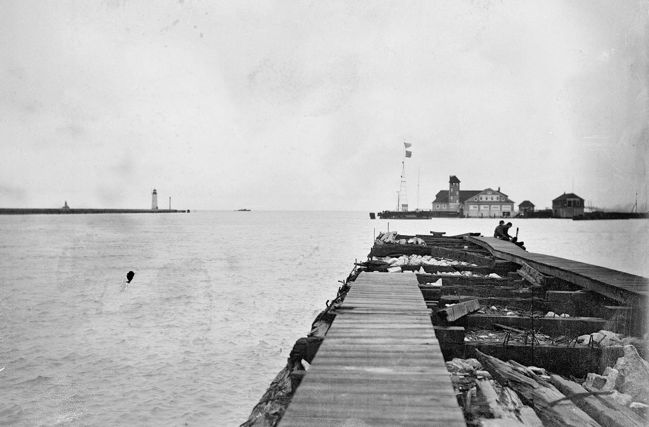 Mouth of Chicago River looking along a pier toward a US Life Saving station on Lake Michigan, Chicago, Illinois, 1910s.