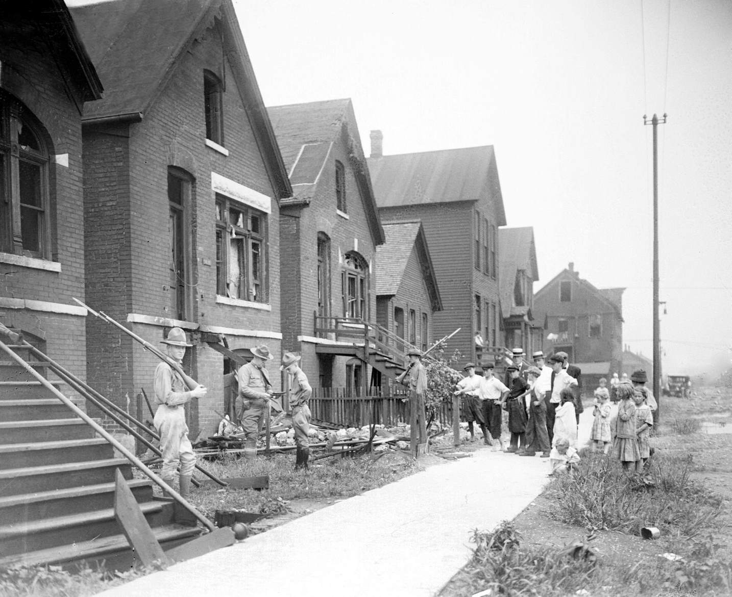 Soldiers stand guard with rifles at a house vandalized during the race riots of July-August 2, 1919 in Chicago, Illinois.