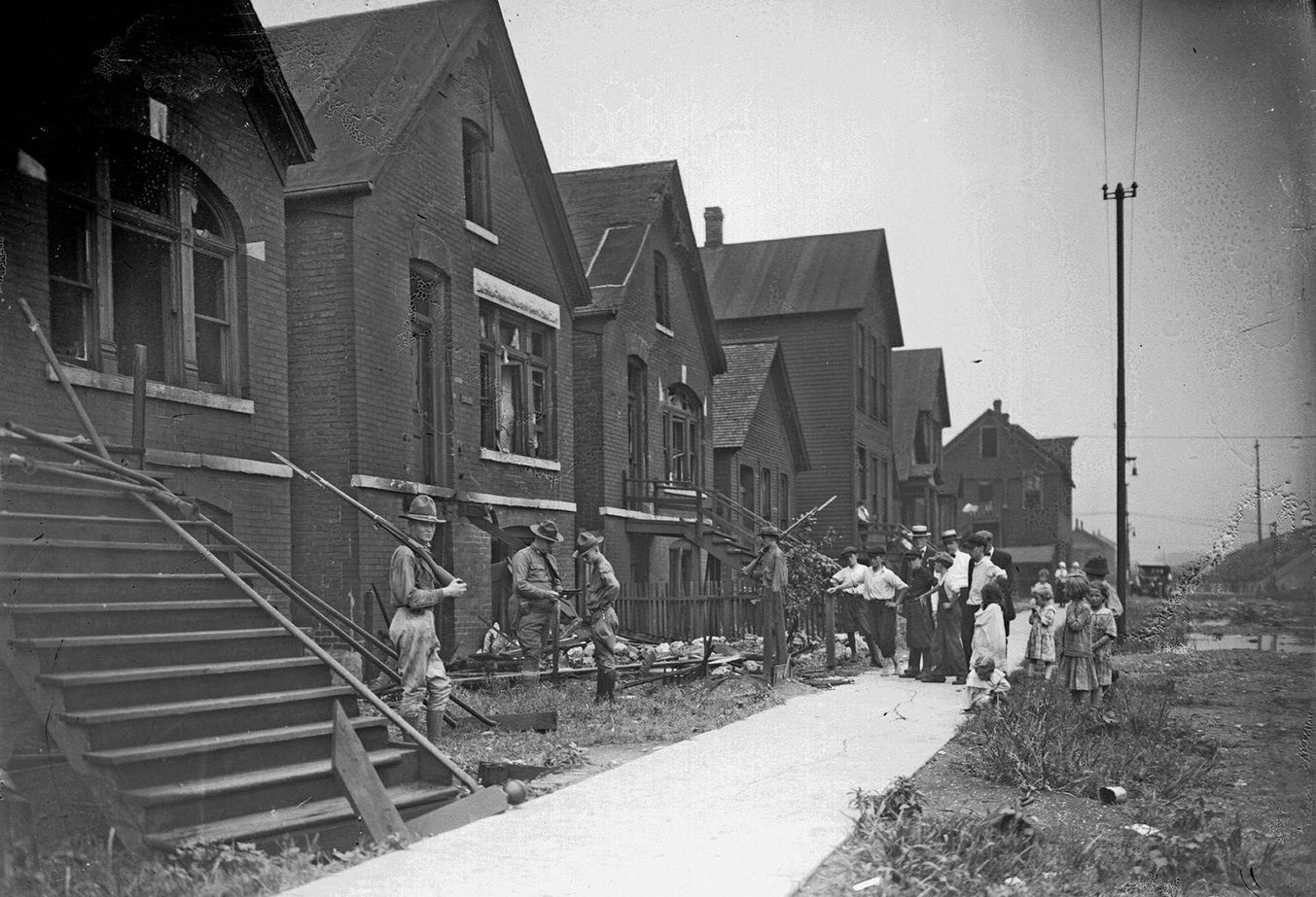 Chicago race riot, soldiers with rifles standing guard at vandalized house, Chicago, Illinois, July 30, 1919.