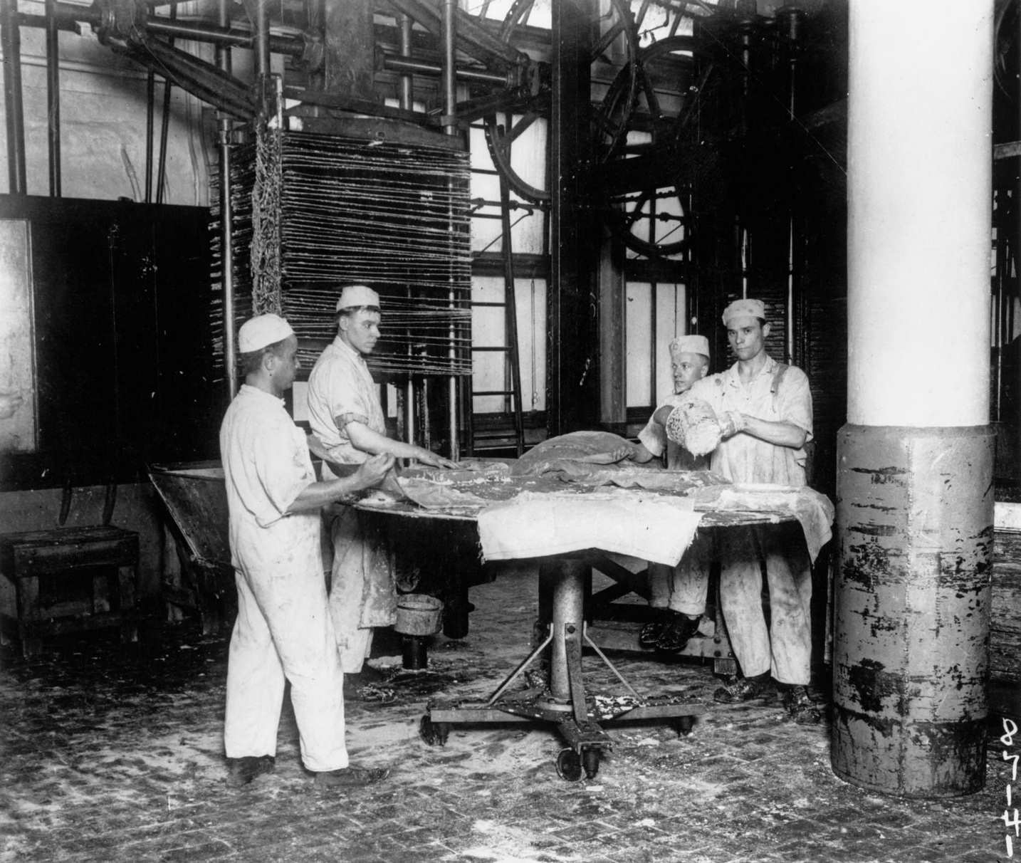 Loading beef fat into an oleomargarine press for the preparation of oleomargarine (margarine) oil at stockyards in Chicago, Illinois, 7th April 1919.