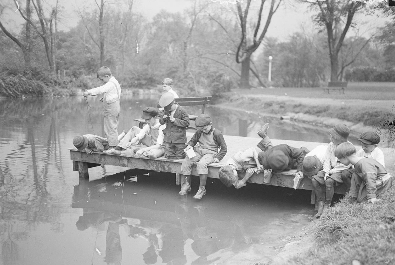 Young boys playing and fishing from a dock in Lincoln Park, Chicago, Illinois, 1919.