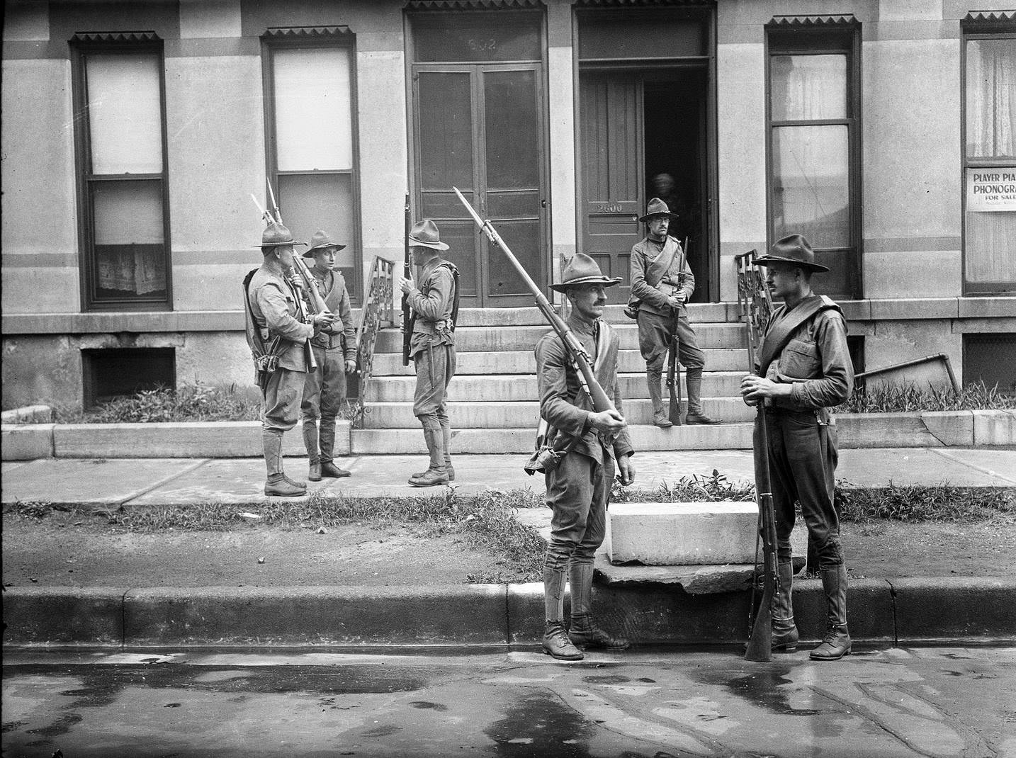 Armed National Guard standing outside apartments during the race riots in Chicago, Illinois, 1919.
