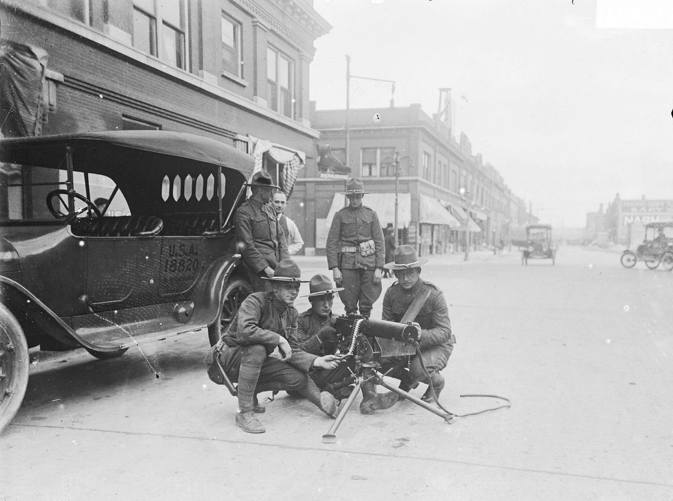 Strike at U.S. Steel Corporation, Gary, Indiana, with three military men squatting around machine gun, Chicago, Illinois, 1919.