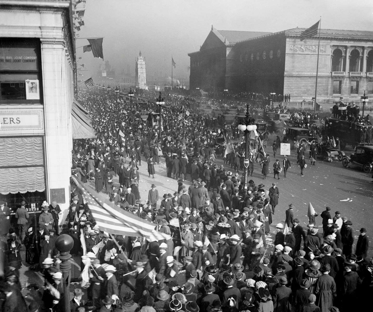 Crowds at the Armistice Day peace celebration marching in front of the Art Institute at 111 South Michigan Avenue in the Loop community area of Chicago, Illinois, 1918.