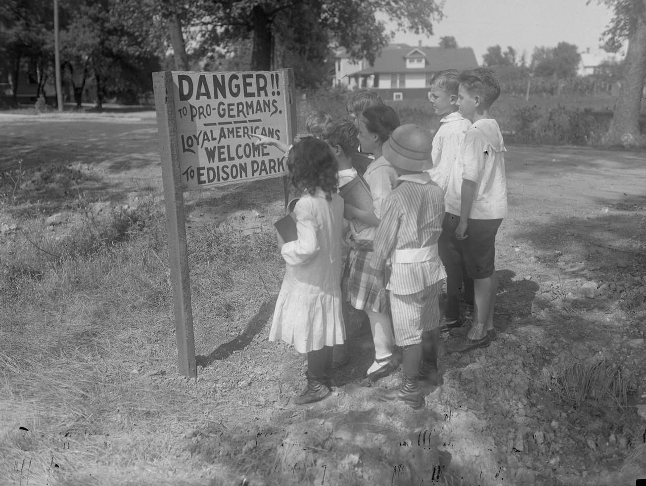Group of children standing in front of an anti-German sign posted in the Edison Park, Chicago, Illinois, 1917.