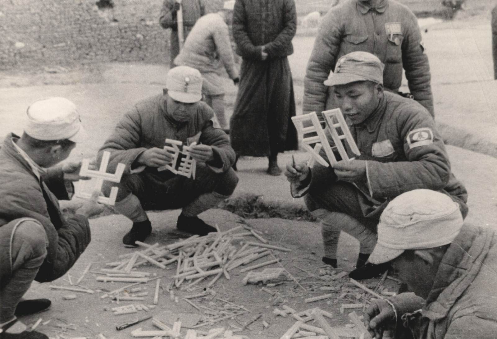 Soldiers of the 84th Kwangsi (Guangxi) Army at Tsaoyang (Zaoyang), Hupeh (Hubei) Province, Central China front, carve Chinese characters (words) out of bamboo and put up slogans against the Japanese.