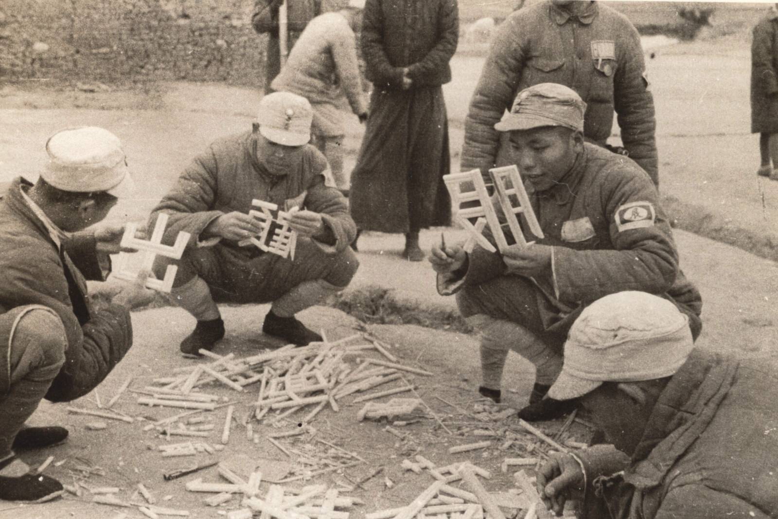 Chinese soldiers, taught reading and writing in the Army, carving Chinese words from bamboo and arranging them into anti-Japanese slogans across the walls of buildings and towns. 1937-1940