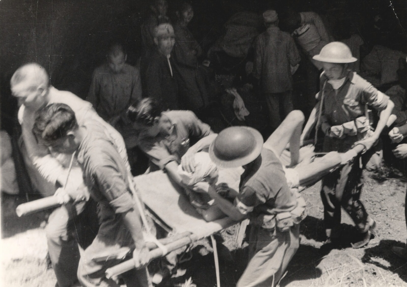 Chinese Red Cross Medical Corps ambulance units at work after a Japanese air-raid. These ambulance workers wear steel helmets and about their waists dressing belts presented to them from the American Red Cross, 1937-1940