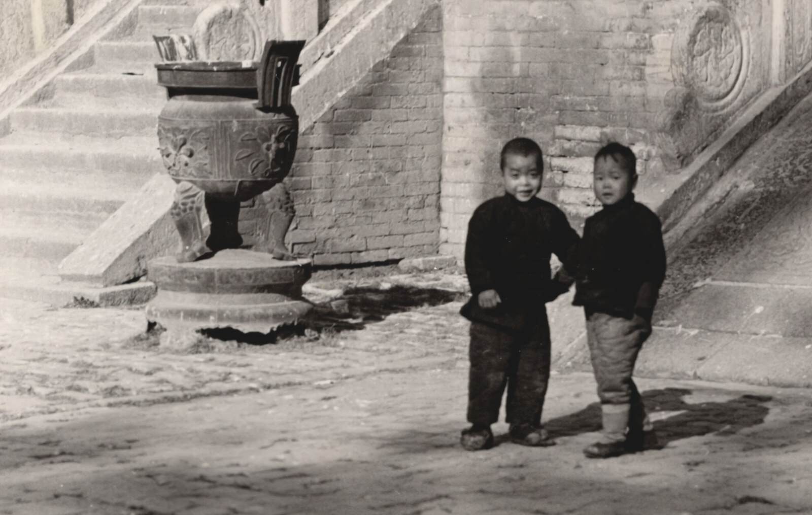 Two Chinese Boys sliding down the balustrade of the old Confucian Temple in Sian(Xi'an). 1937-1940