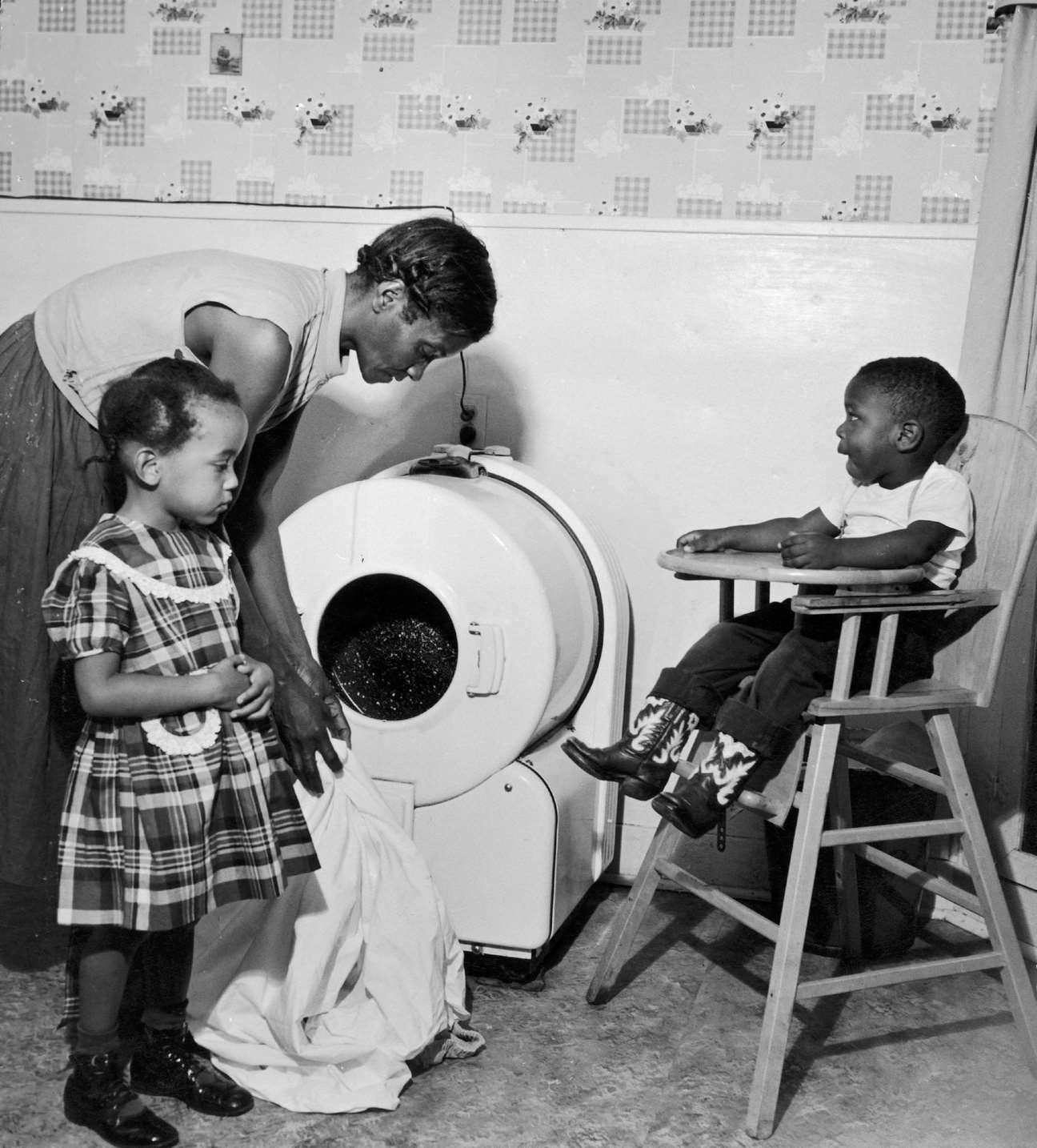 A mother washes clothes in the presence of her children in Dallas, Texas, 1950