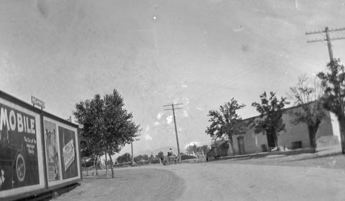 Road with wagon, billboards and building, 1907