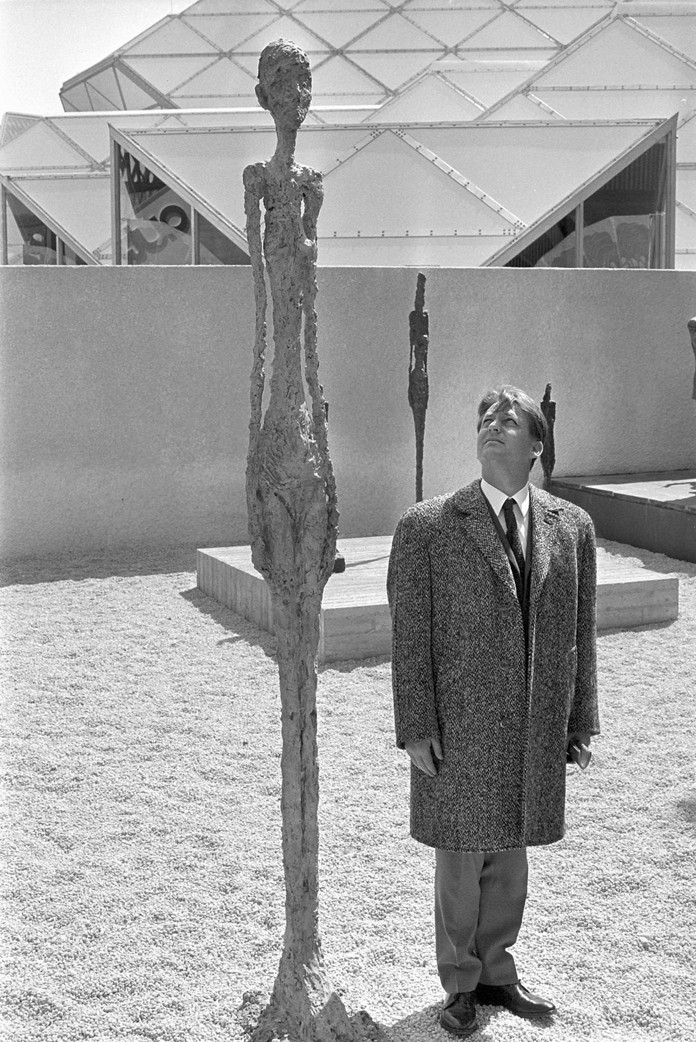 Man beside sculpture of Giacometti, Expo 1967
