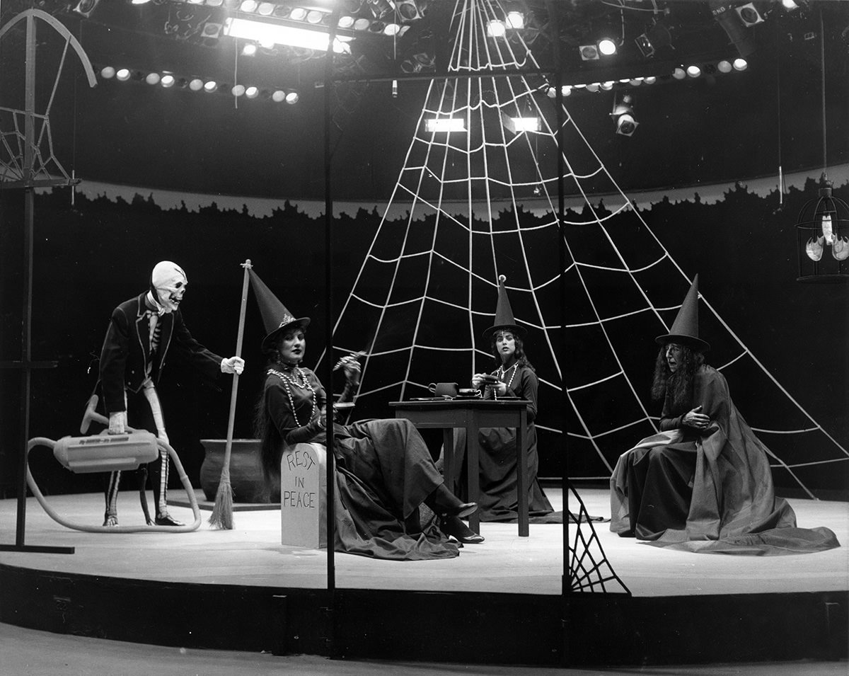 Casa Manana - Three women dressed as witches lounging on stage, a skeleton butler with broom and vacuum in "Wizard of Oz," 1961.