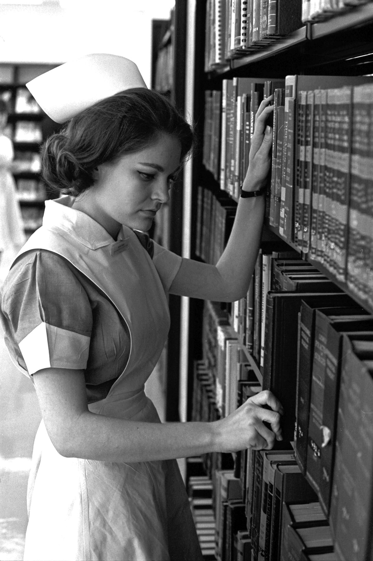 Miss Alita Rose, president of one of the two classes of student nurses at John Peter Smith Hospital School of Nursing, locates a book in the library and prepares to spend a couple of hours in quiet study, 1965