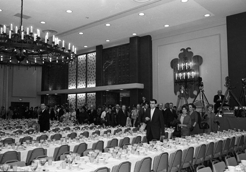 People entering Hotel Texas Grand Ballroom with tables set for breakfast for President John F. Kennedy and party, 1963