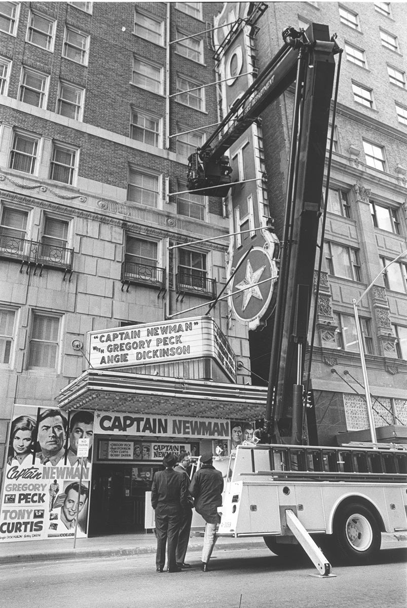 Fire truck adjusts Worth Theater sign, 1964