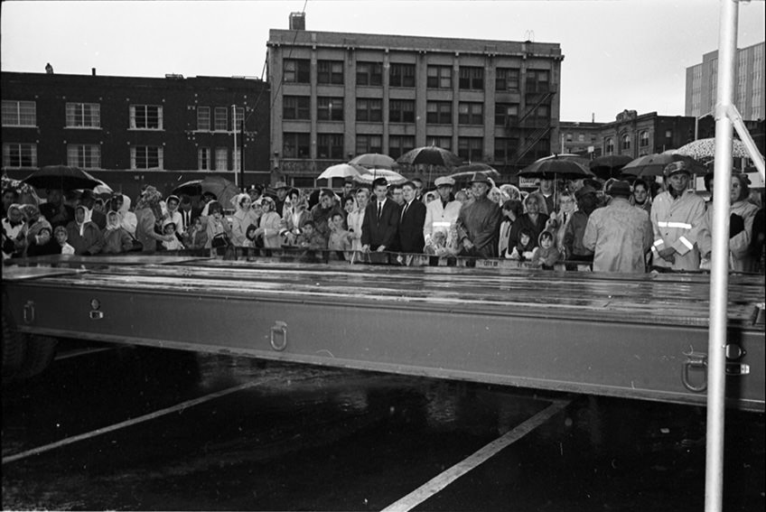 Flatbed truck brought in for President John F. Kennedy to speak from to crowd outside Hotel Texas; crowd begins to gather, 1963