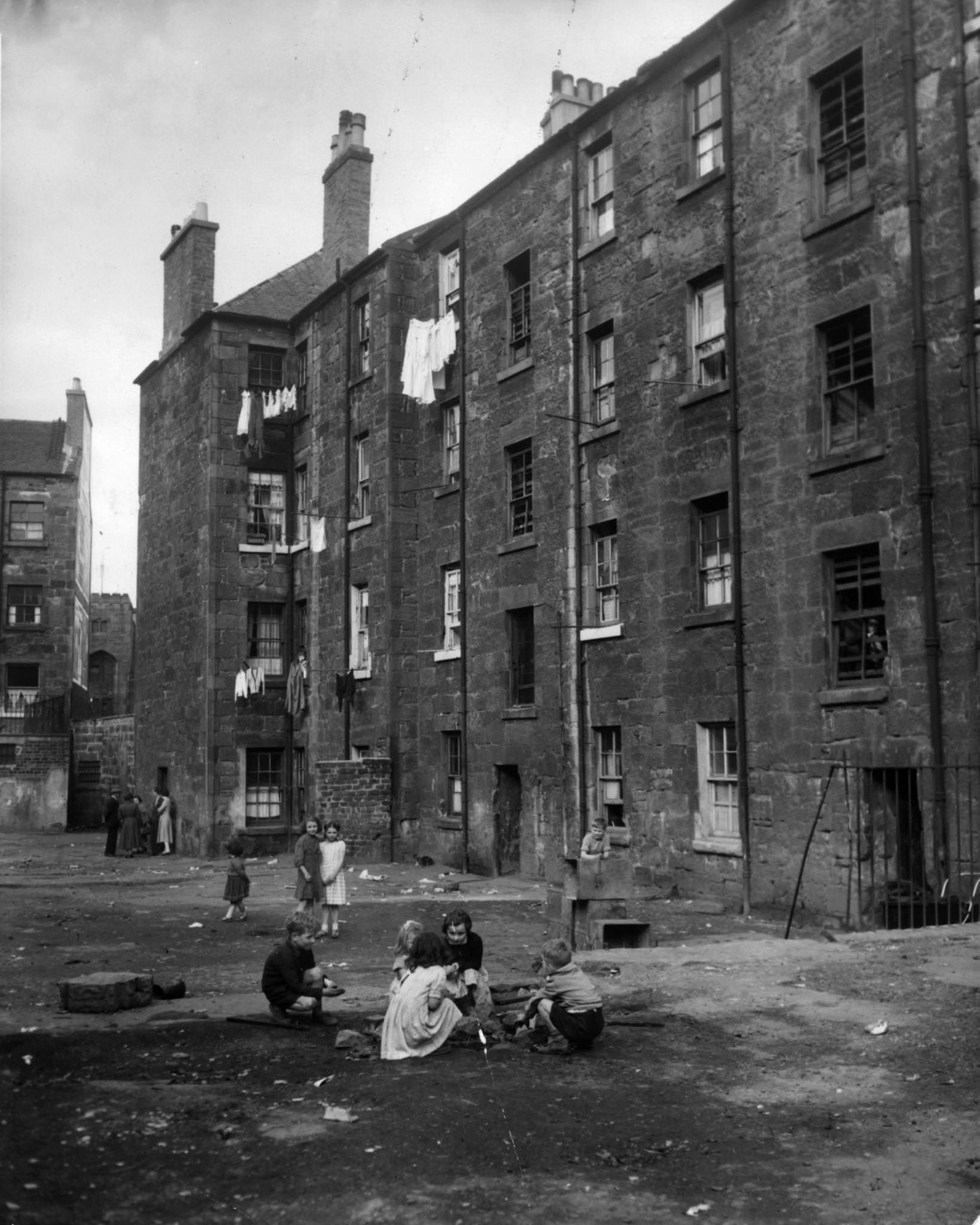 Children play on waste ground outside a tenement block in Camden Street, the Gorbals, Glasgow, 1956