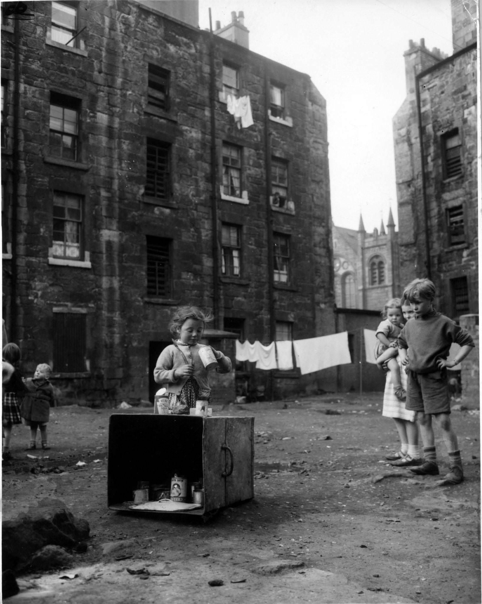 September 1956: Jenny Lamont and her friends play with tin cans in the yard behind tennemants of Florence Street, in the Gorbals area of Glasgow, 1956