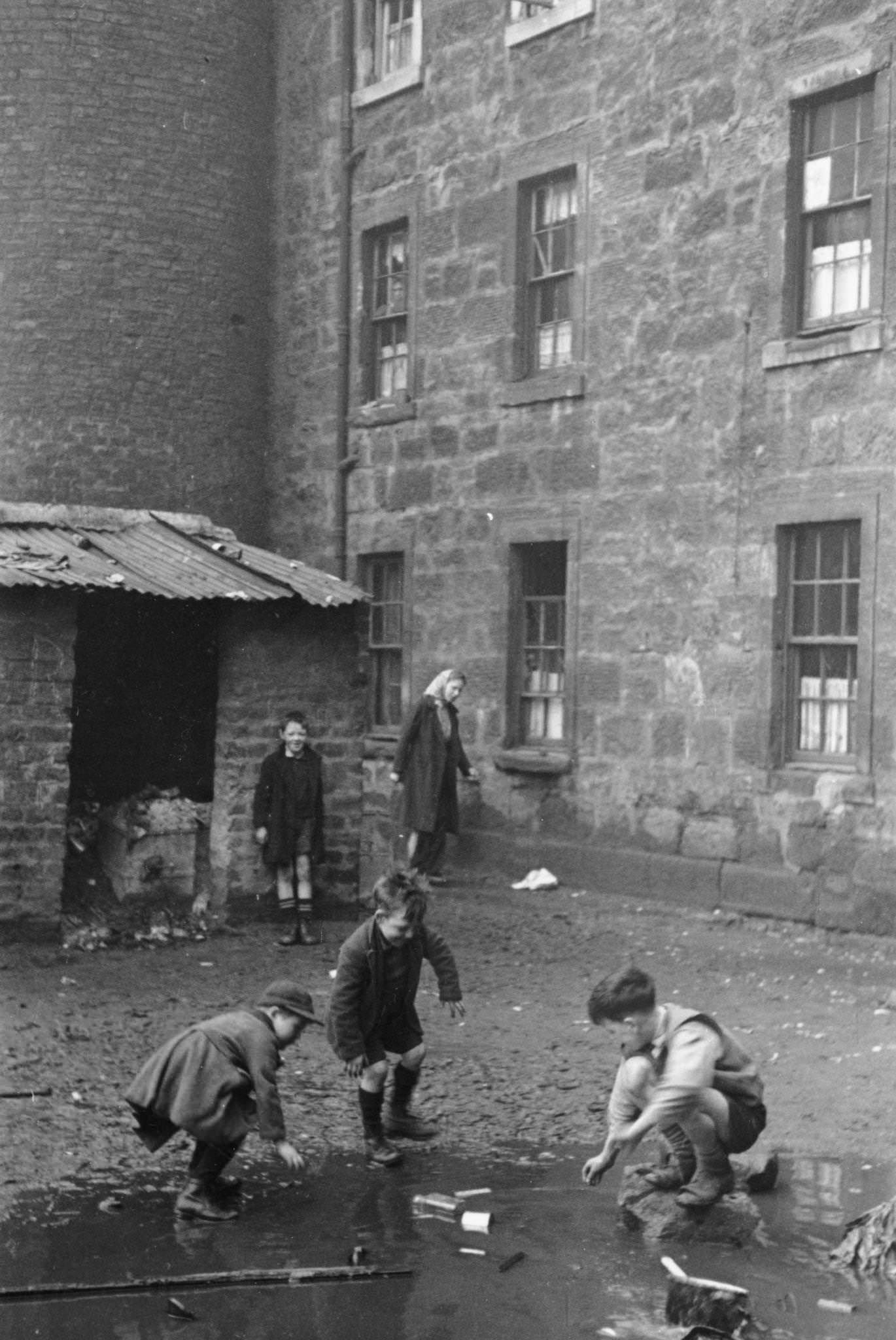 Boys play in a puddle in the slums of Gorbals, Glasgow, 1948