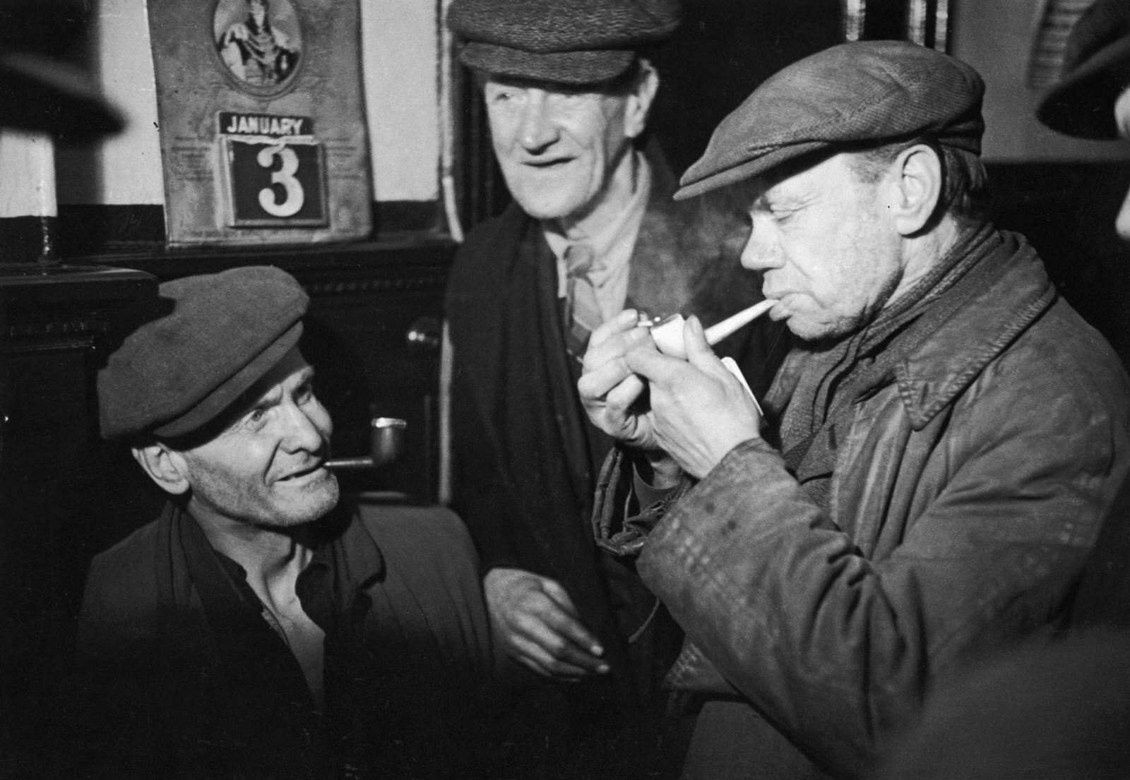 Men from the Gorbals, Glasgow's slum area, meet in the local pub for a friendly smoke, 3rd January 1948.