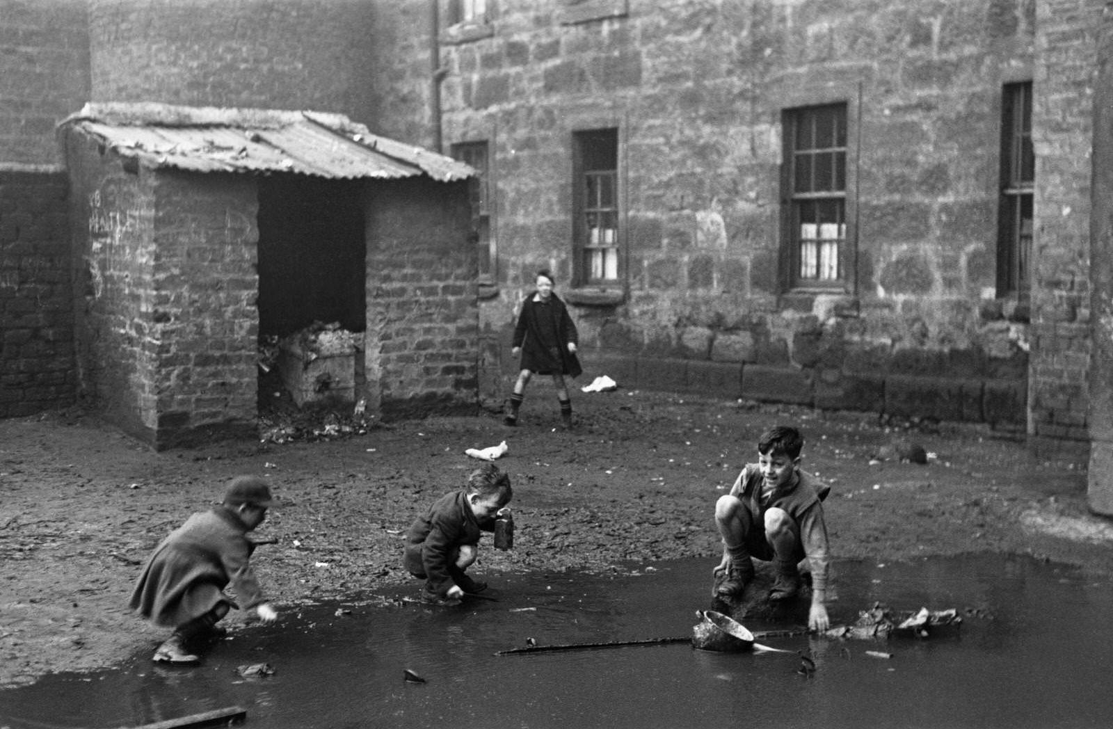 Children play in a yard with the 'Gorbals', a notorious slum area of Glasgow, January 1948.