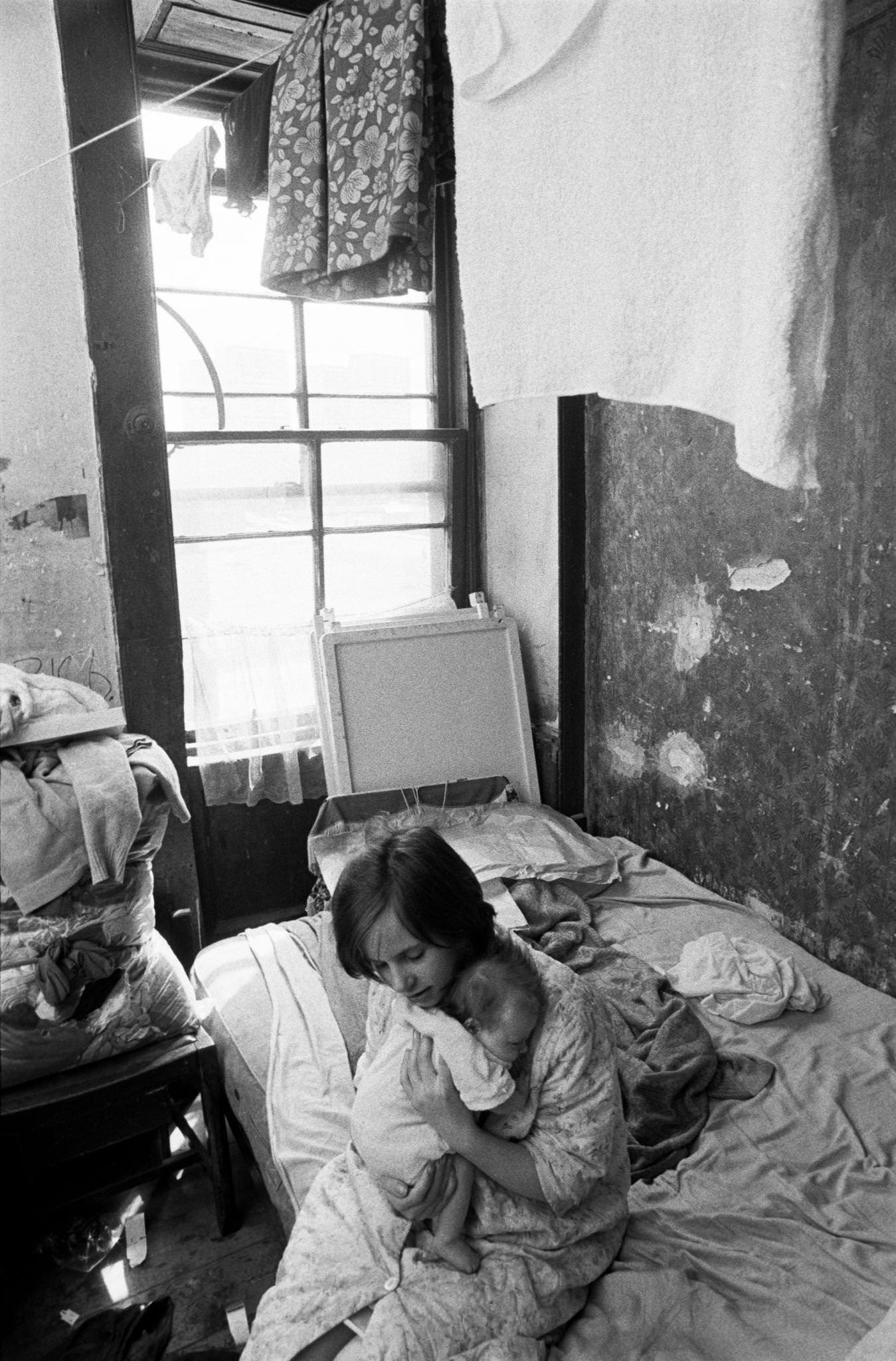 A young girl holding a little baby in her flat in the notorious Gorbals district of Glasgow, 1969.