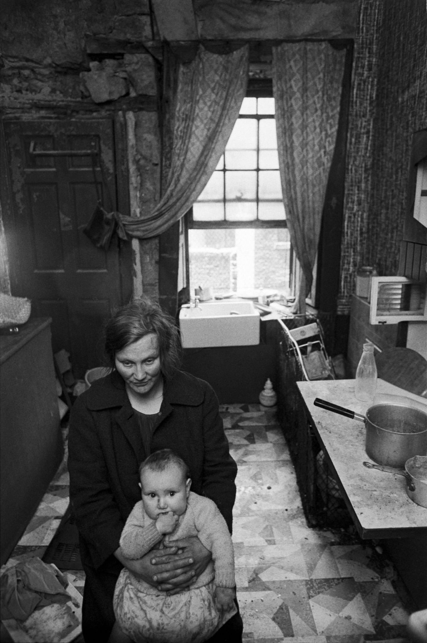 A mother holding her child in the kitchen of her flat in the notorious Gorbals district of Glasgow, 1969.
