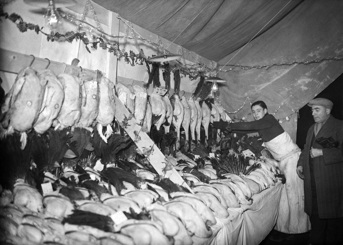 A butcher sells his poultries at Les Halles district (central food market) in Paris on December 1938.