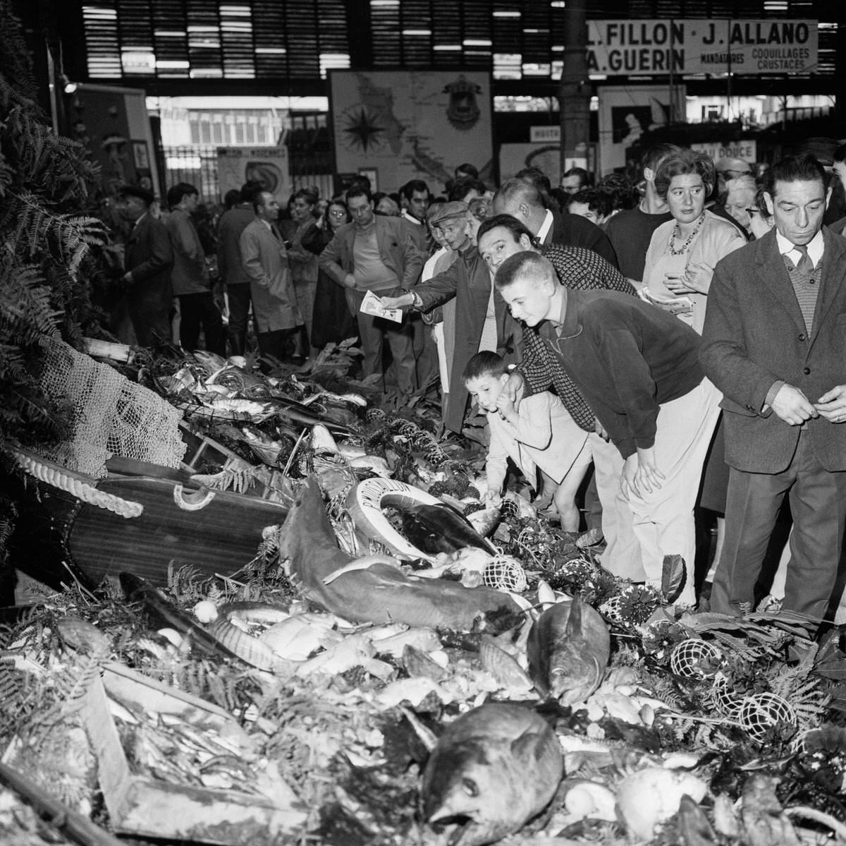 The crowd admires the largest buffet in the world where fish of all kinds are artistically presented for the great fish fair, in Paris, 1967