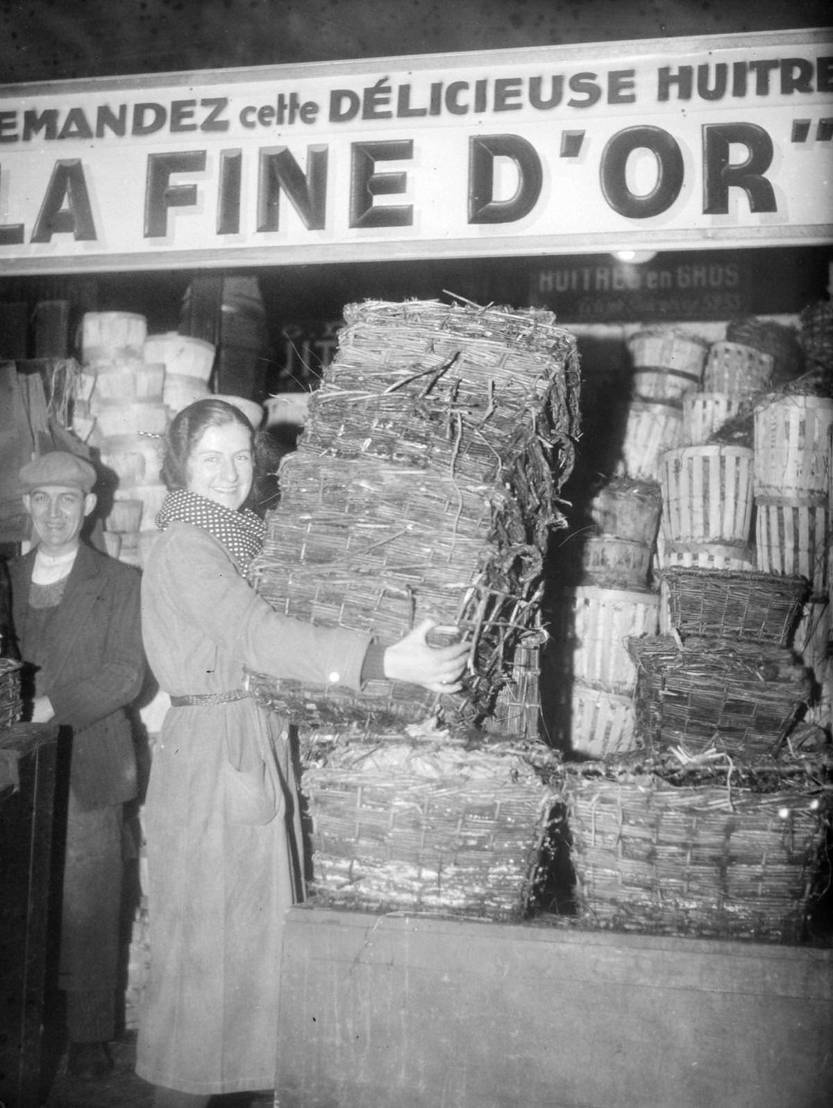 Employee setting up a large shipment of oyster baskets at Les Halles in Paris, France, on December 22, 1934.