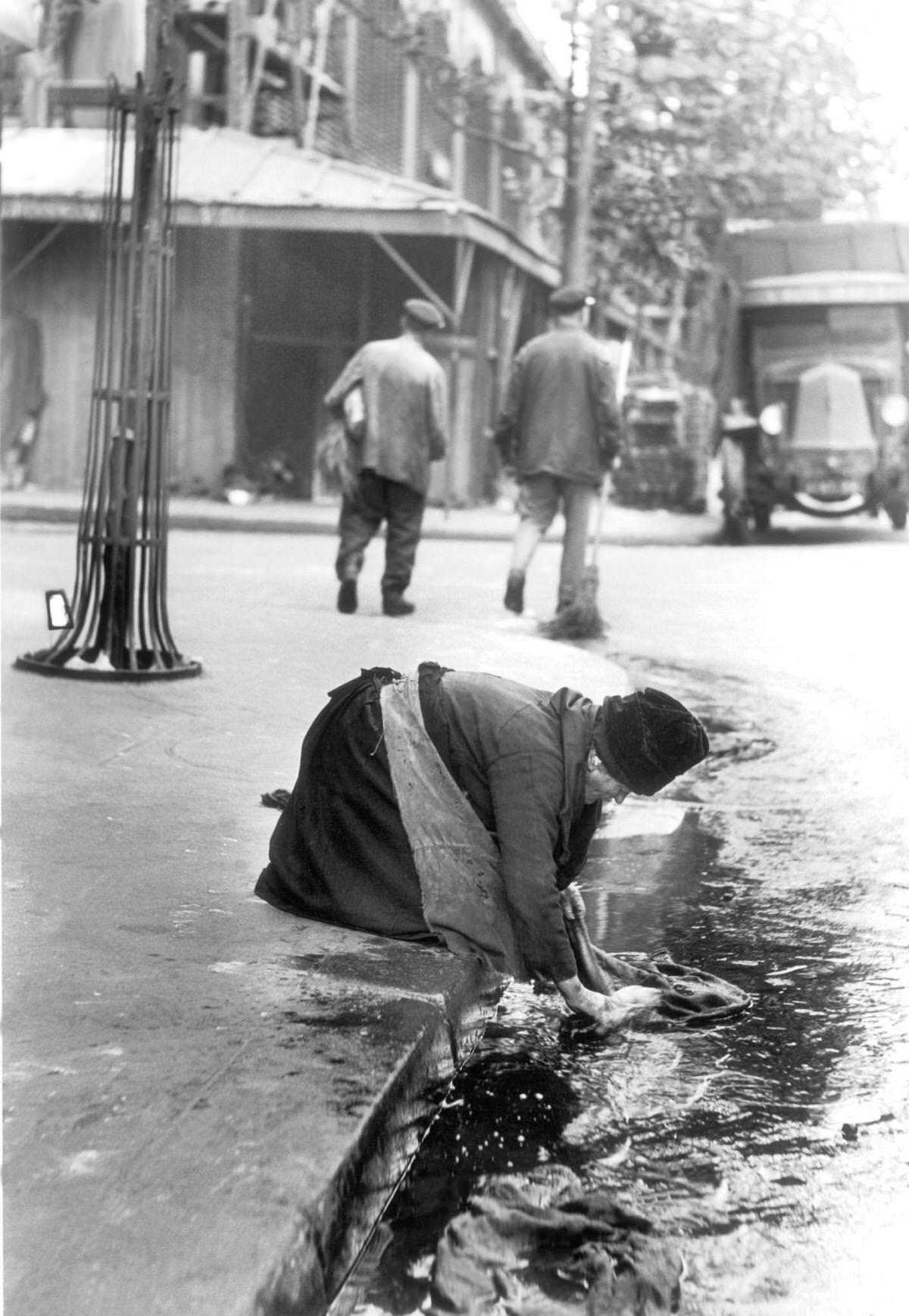Seller in les Halles market washing her bags in the gross which would be filled up with some other fruits and vegetables on the following day, 1931