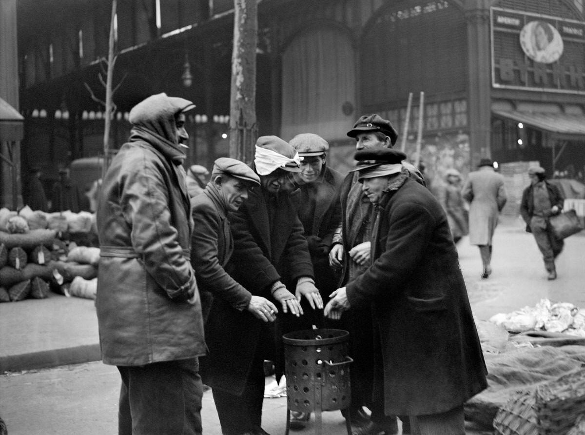 Men warming up around a brazier, during the season of winter, in the street of the Les Halles district, 1930s