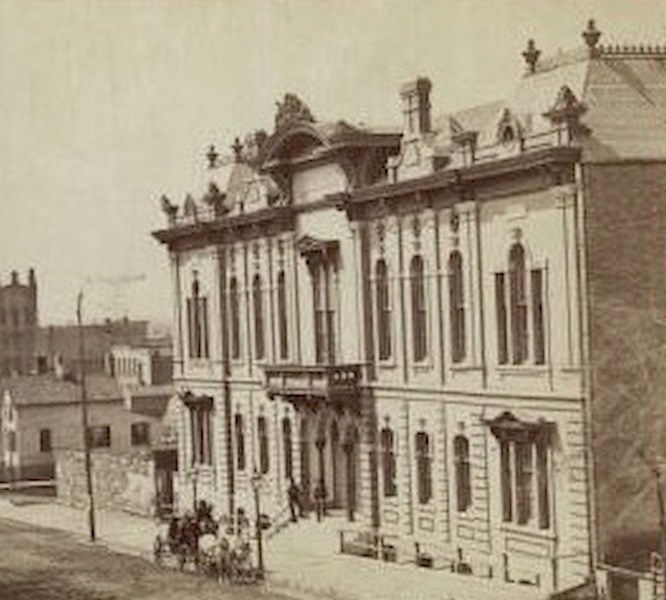 Front of music hall along the road, with a horse and carriage team in front of the entrance, 1880