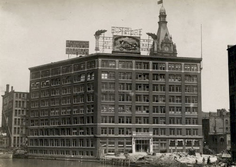 Building from across the river, with construction workers working nearby, 1895