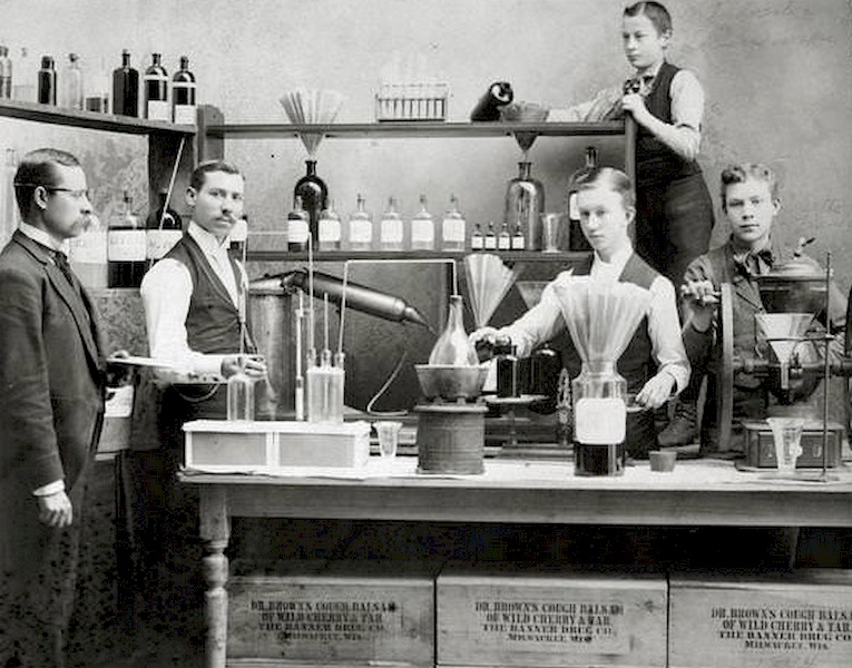 Workers posing in front of pharmaceutical equipment to demonstrate the making of Dr. Brown's Cough Balsam at Kienth Drugs and Medicines, 608 Mitchell Street, 1896